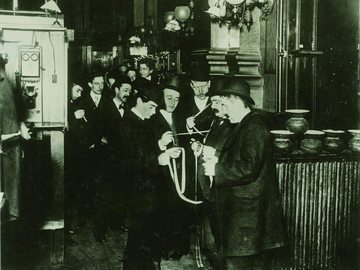 Men on floor of New York Stock Exchange looking at ticker numbers