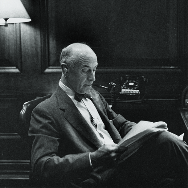 Roland Harriman sitting in office Partner room reading business notes