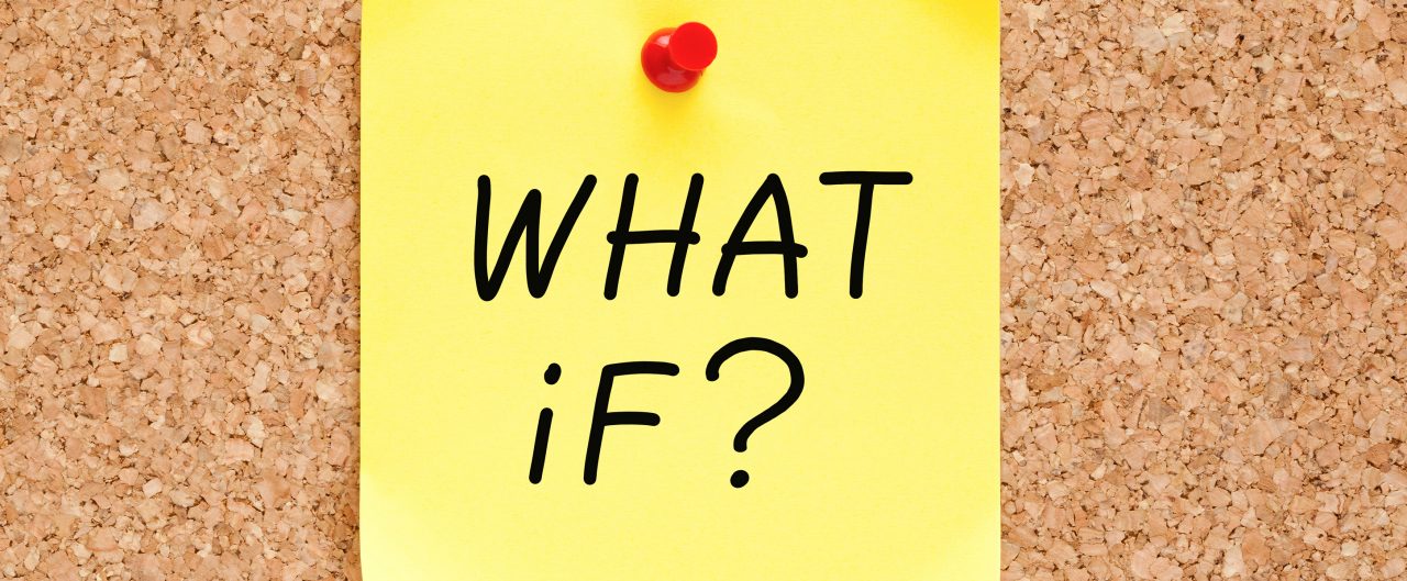 Yellow post-it-note pinned to a board with 'What if?' written on it