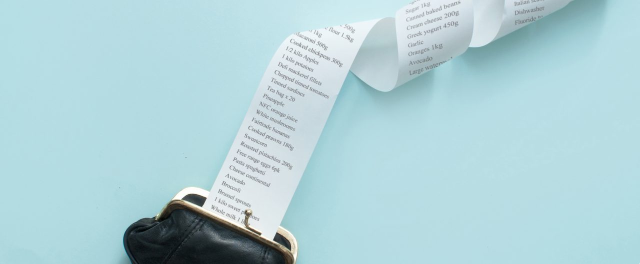 long grocery list coming out of coin purse