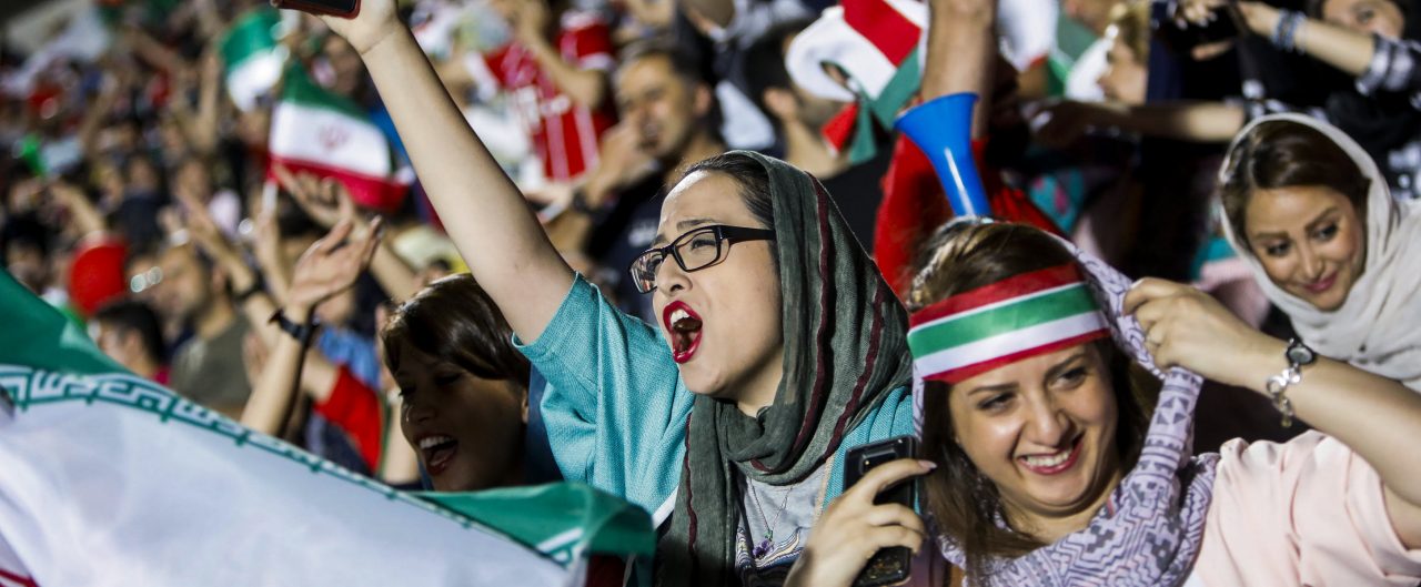 Iranian football supporters wave their national flags as they cheer for their national team during a screening of the Russia 2018 World Cup Group B football match between Iran and Spain in Azadi stadium in the capital Tehran on June 20, 2018. - Tehran's largest football stadium on June 20, 2018 admitted thousands of women together with men for the first time since the Islamic revolution of 1979 as World Cup fever gripped Iran for its evening group game against Spain. (Photo by STRINGER / AFP) / The erroneous mention[s] appearing in the metadata of this photo has been modified in AFP systems in the following manner: [STRINGER] instead of [ATTA KENARE]. Please immediately remove the erroneous mention[s] from all your online services and delete it (them) from your servers. If you have been authorized by AFP to distribute it (them) to third parties, please ensure that the same actions are carried out by them. Failure to promptly comply with these instructions will entail liability on your part for any continued or post notification usage. Therefore we thank you very much for all your attention and prompt action. We are sorry for the inconvenience this notification may cause and remain at your disposal for any further information you may require.        (Photo credit should read STRINGER/AFP/Getty Images)
