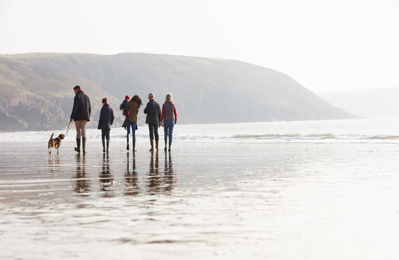 A group of people walking on the beach