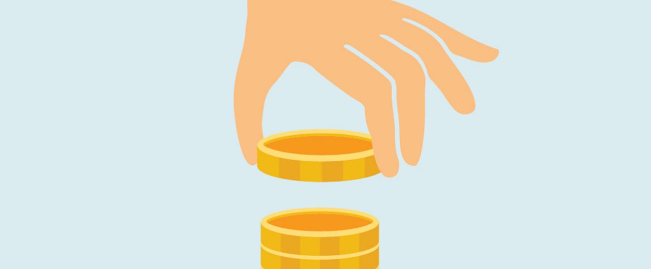 A hand picking up a coin off of a stack of coins