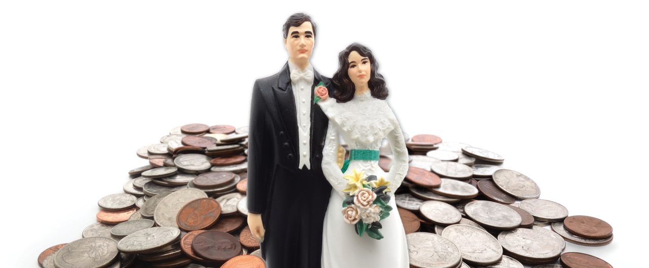 Plastic figures of a married couple, with a pile of coins behind them