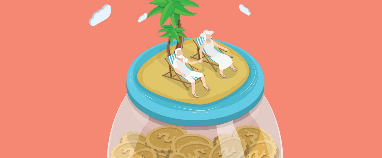 A senior-aged couple sit together on a beach on top of a giant coin-jar to symbolize living on retirement savings
