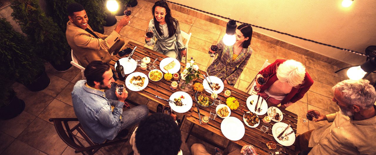 multiethnic group of people dining on a rooftop. Family and friends make a reunion