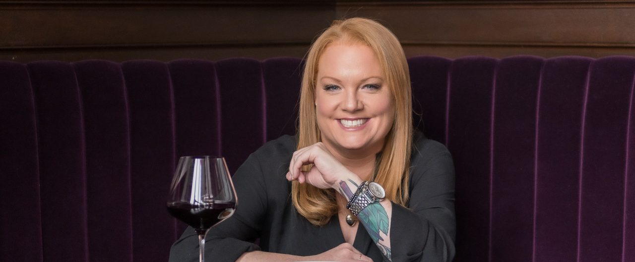 Tiffany Faison with a glass of wine in front of her