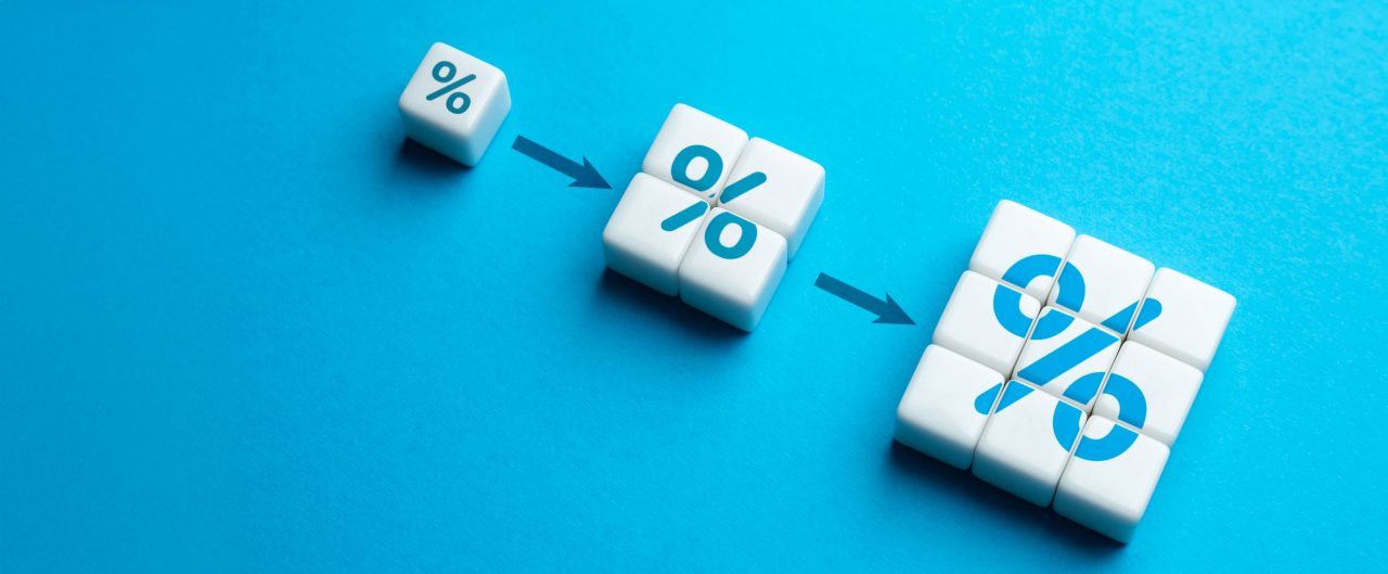 Three people standing area financial charts and graphs and life-size bit-coin symbols