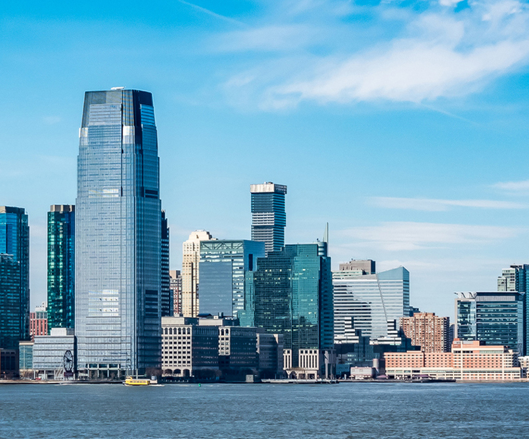 New Jersey city skyline seen past a large blue body of water