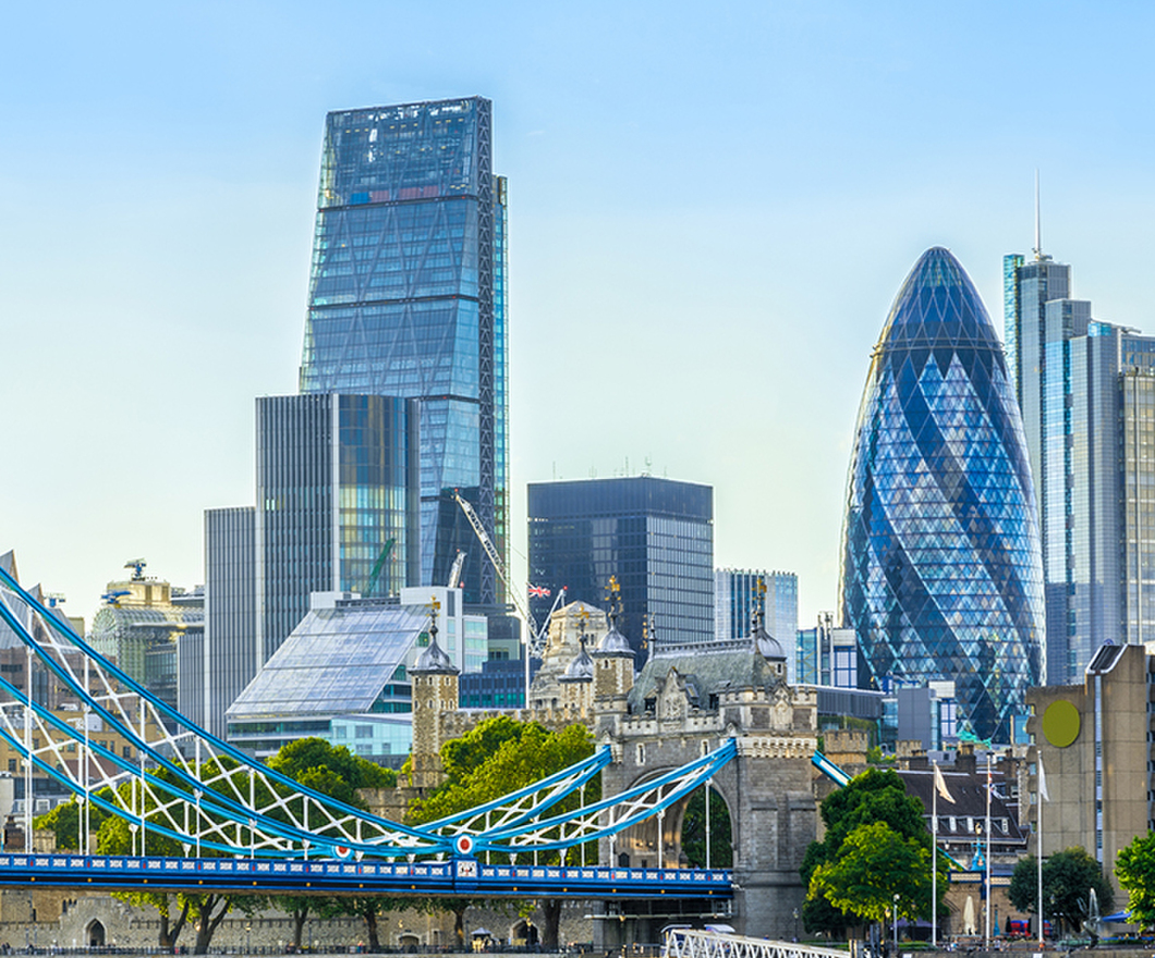 Tower bridge and financial district of London with a cloudless sky at sunset