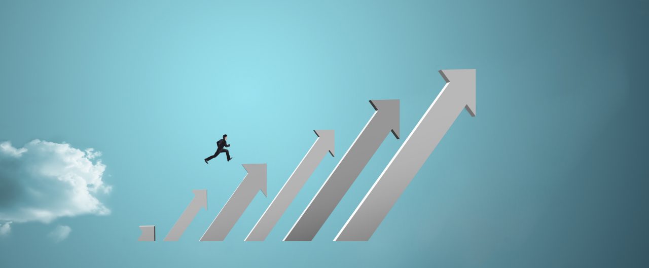 businessman jumping on growing chart with sky background