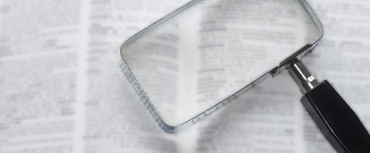 Spanish dictionary out of focus with area in focus by magnifying glass. Presbyopia. Older people