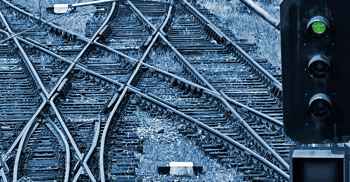 Close up of train tracks and a traffic light with the green light showing