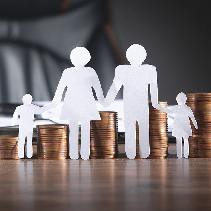 Hand holding a paper family and umbrella on green background