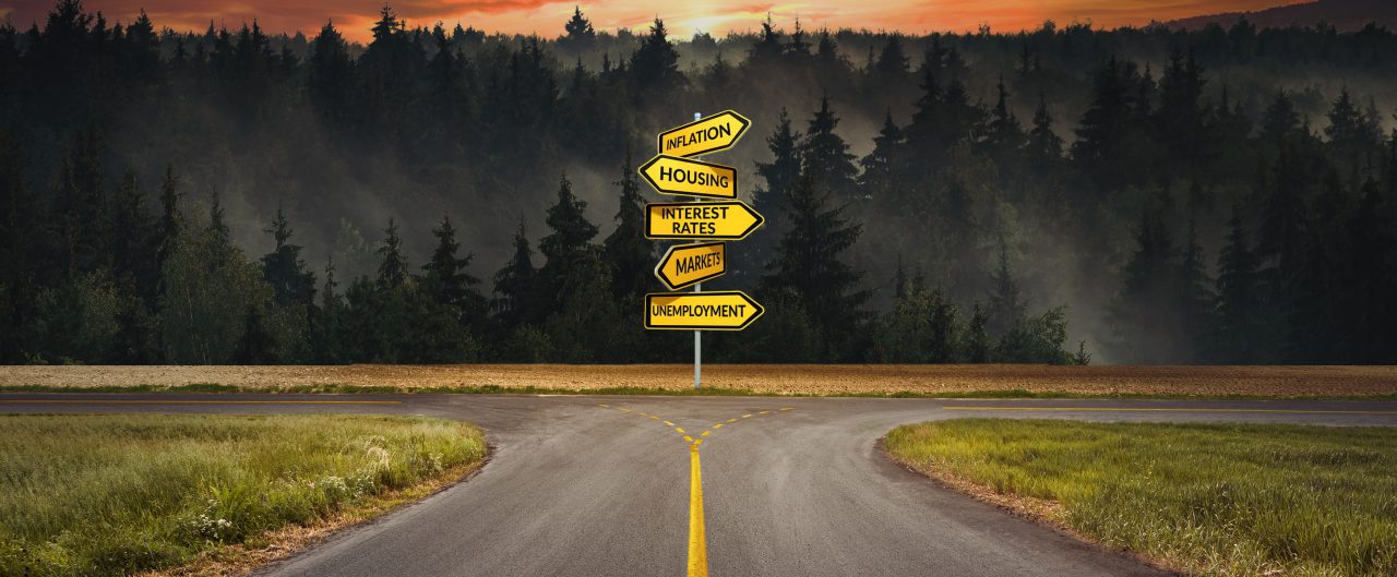 InvestorView cover of a road intersection with a sign post with the words inflation, housing, interest rates, markets and unemployment.