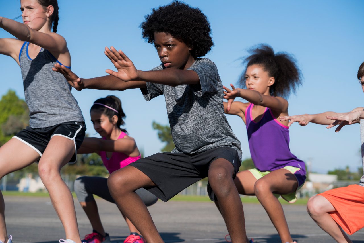 Several children exercise together outside