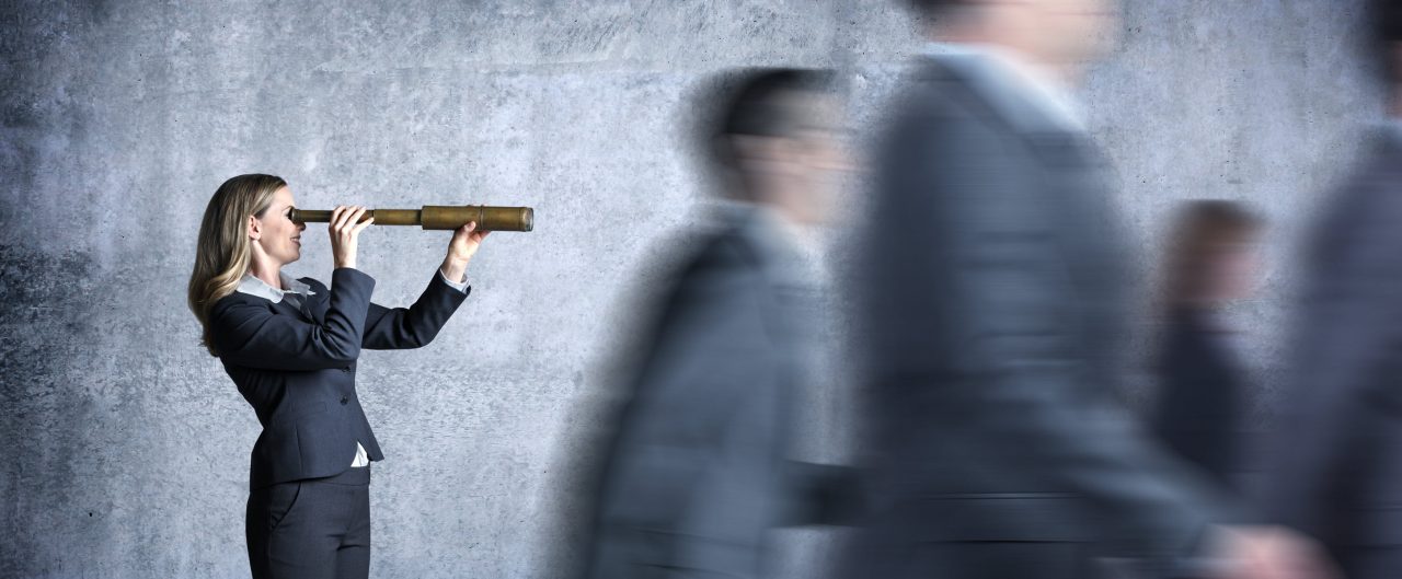 A businesswoman looking through a telescope with blurred people walking
