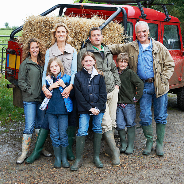 Multi-generational family standing in front of a truck  while smiling