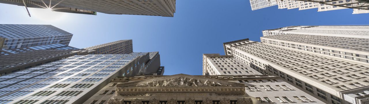 New York Stock Exchange and statue taken from down below with a clear blue sky_banner