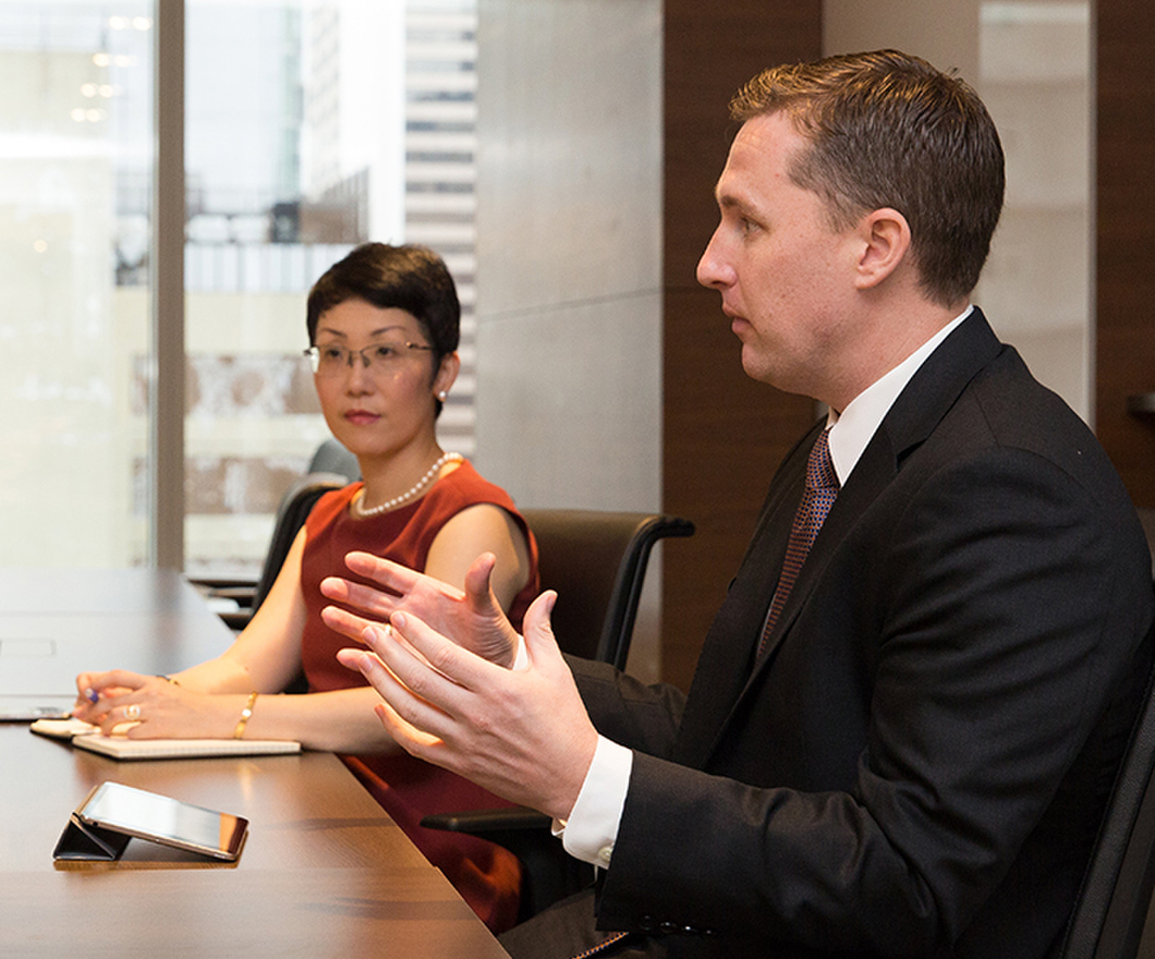 Male and female employees talking at conference room table