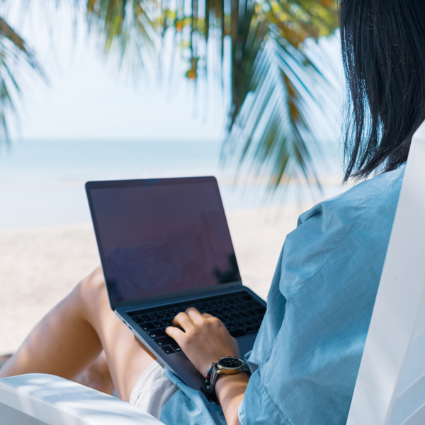 Woman using laptop and smartphone to work study at beach