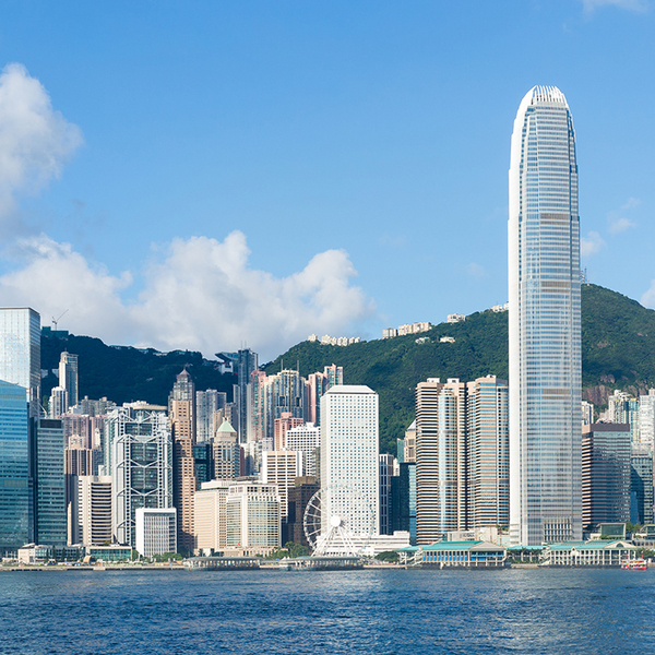 Hong Kong view from Victoria Harbour on sunny day with green mountains in the background