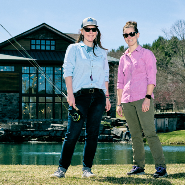 Jackie Kutzer and Christine Atkins in front of lake with fishing pole