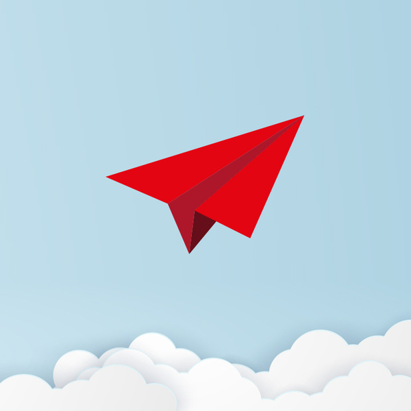 Red Paper airplane in the sky above white fluffy clouds