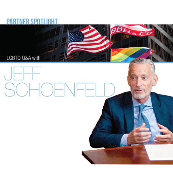 Jeff Schoenfeld with The American flag, BBH flag, and LGBTQA+ flags behind him