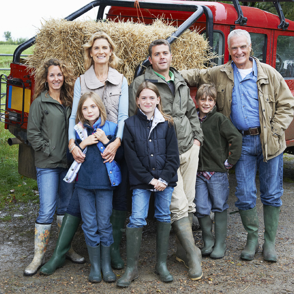 Family of seven in front of a truck and hay bail 