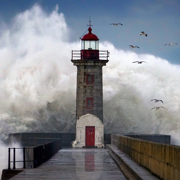 Wave crashing over the Douro Lighthouse, Porto, Portugal