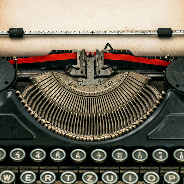 an old-fashioned typewriter with blank paper in it