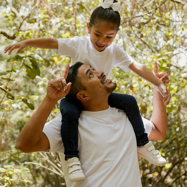 Family walking in the park-father playing with his daughter in the park