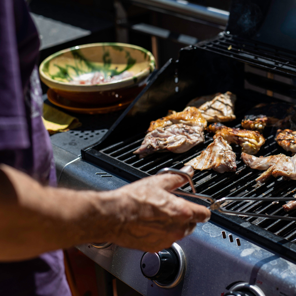 man preparing meat on barbeque