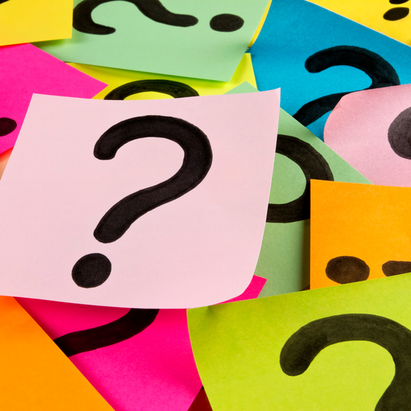 Pile of colorful sticky notes with hand drawn question marks. It is a seamless background which was created with adhesive note papers.