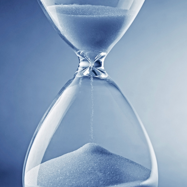 Closeup of an hourglass on a blue background