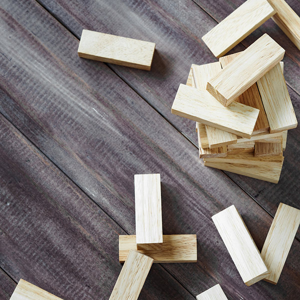 Scattered wooden jenga pieces on a wood background