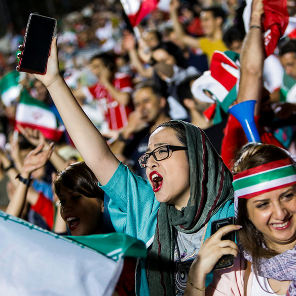 Iranian sports team supporters cheer in the stands at a game