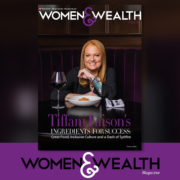 Tiffani Faison with a plate of food and a glass of wine in front of her