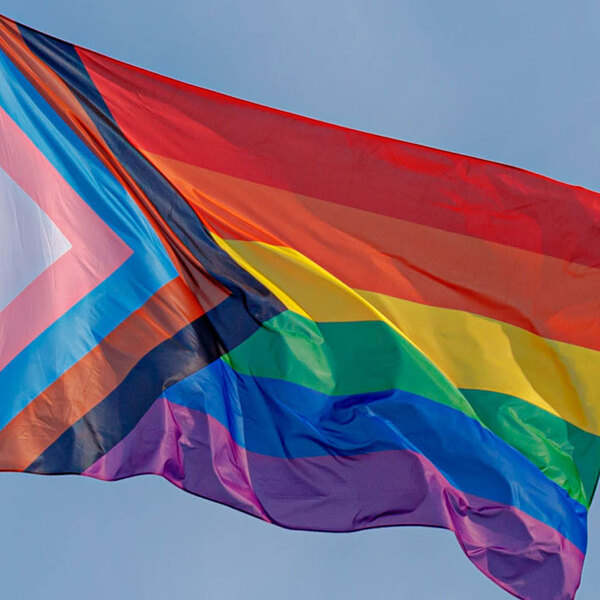 Progress pride flag (new design of rainbow flag) waving in the air with blue clear sky, Celebration of gay pride, The symbol of lesbian, gay, bisexual and transgender, LGBTQ community in Netherlands.