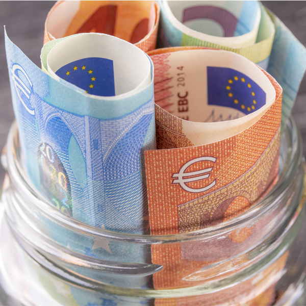 Glass jar with rolled-up euro bills