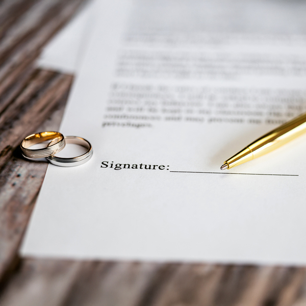 Marriage contract with two golden wedding rings and gold pen, prenuptial agreement, macro close up, sign with signanture,document,agreement concept romance