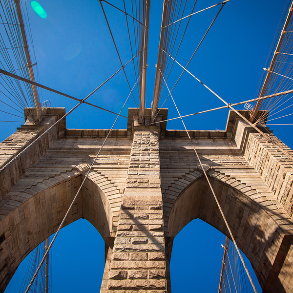 Upward View of the Brooklyn Bridge Against Bright Blue Sky