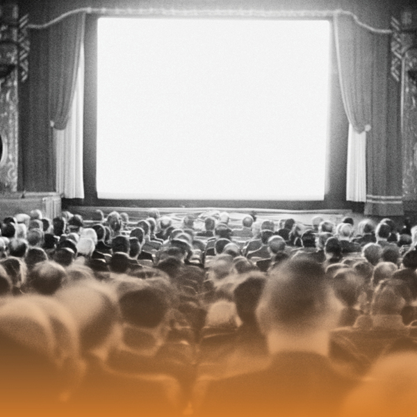 Black and white image of an old theatre showing the crowd and screen
