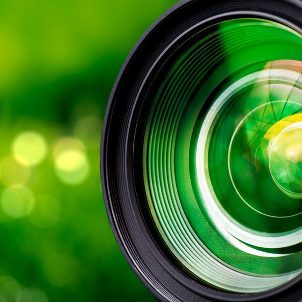 Camera lens on blurry green background