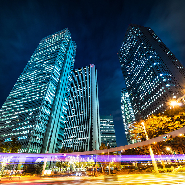 Looking up night view in road intersection of shinjuku, the silhouettes of skyscrapers reflect twilight sky in Tokyo, Japan