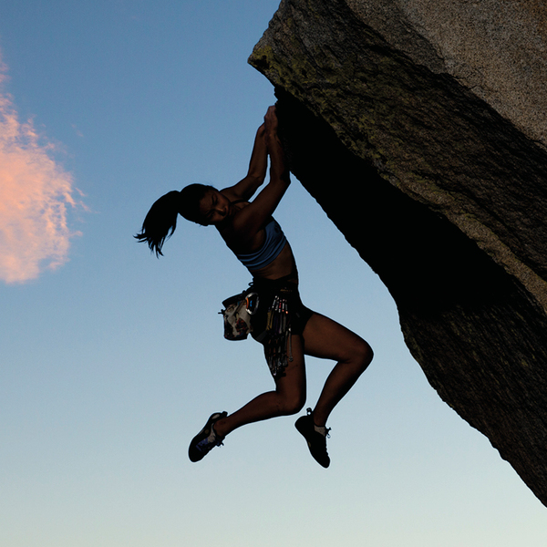 Rock climber clinging to a cliff