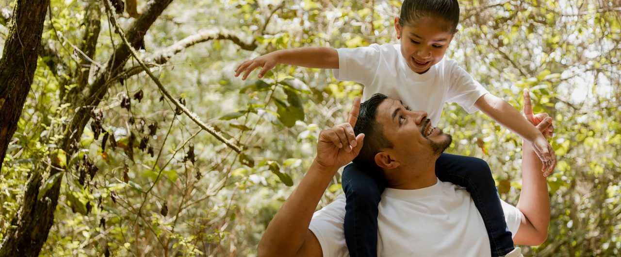 Family walking in the park-father playing with his daughter in the park