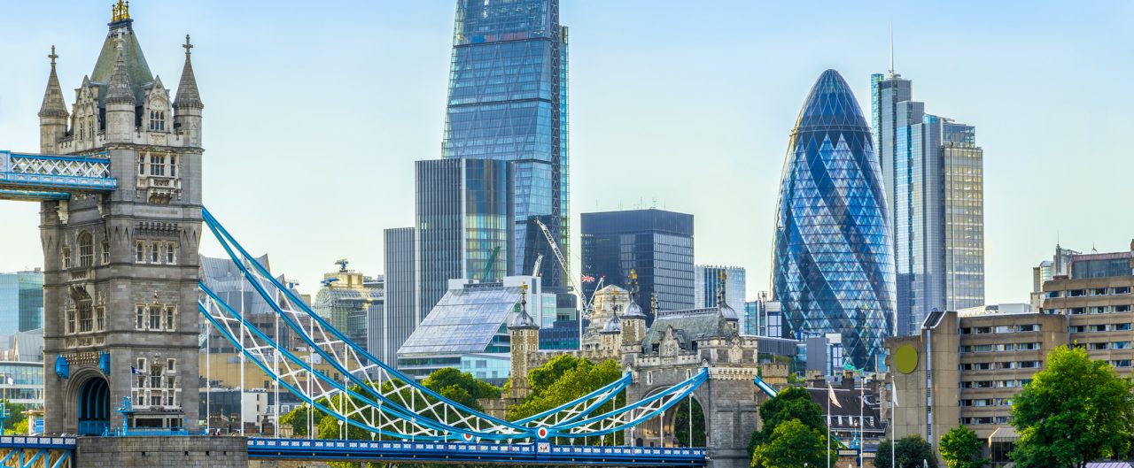 Tower bridge and financial district of London with a cloudless sky at sunset