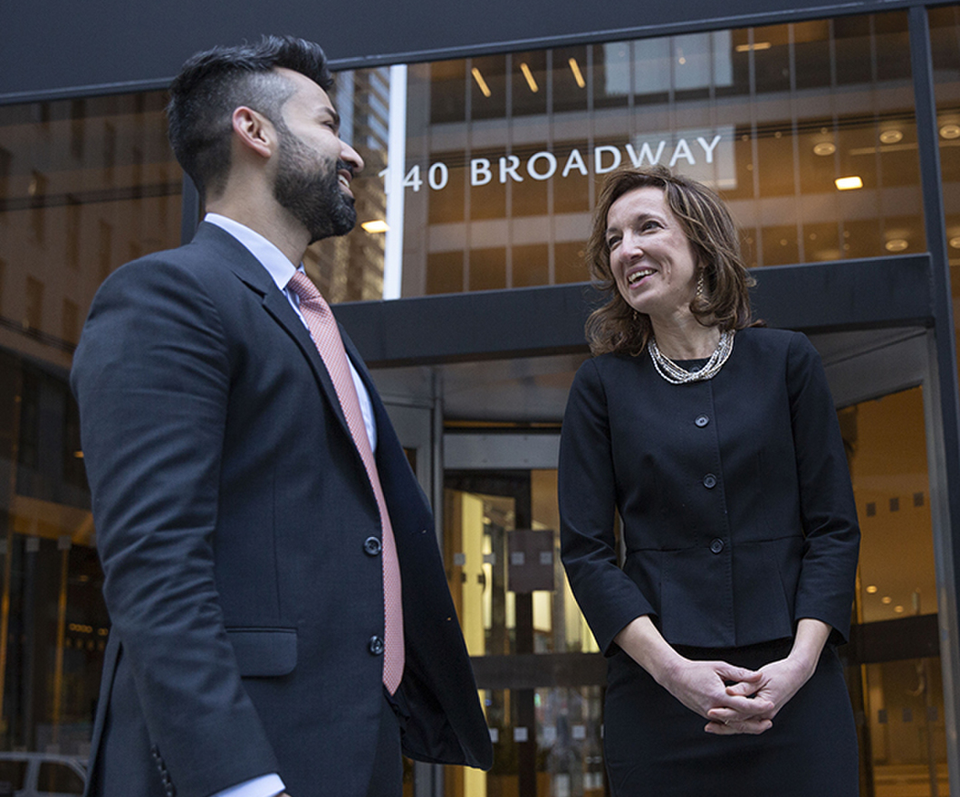 2 BBH'ers standing outside of NY office entrance having a work discussion